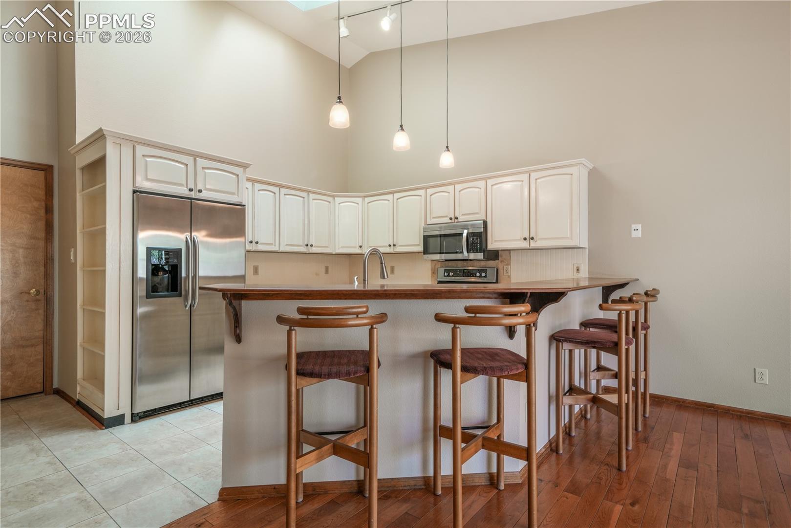 Kitchen with additional bar seating, hard wood floors, updated appliances and granite countertops 