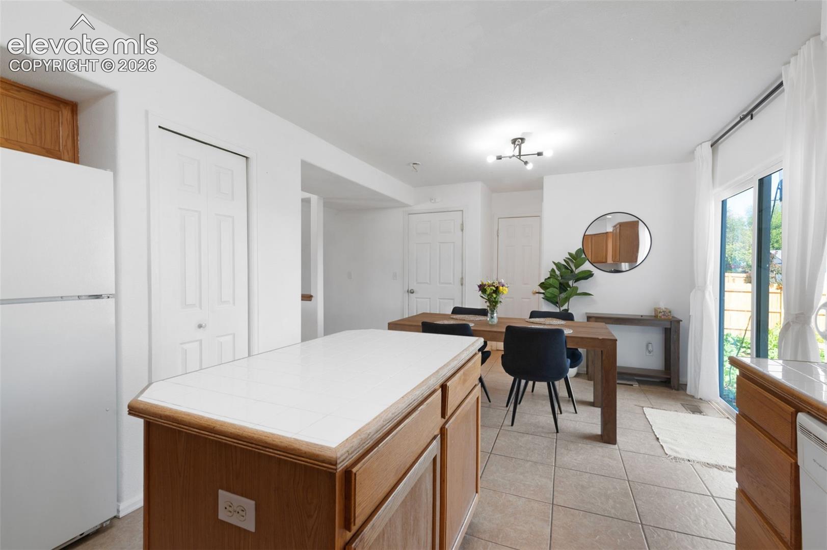 Kitchen featuring wood-finish cabinetry, white tile countertops, and integrated appliances