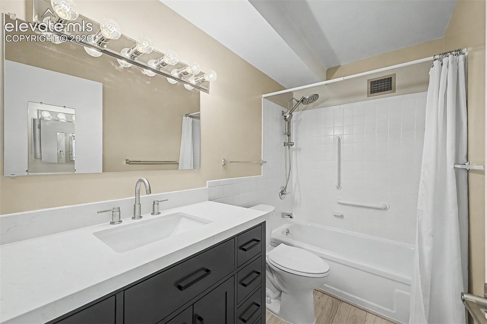 Bathroom featuring a dark wood-finish vanity with a white countertop and an undermount sink