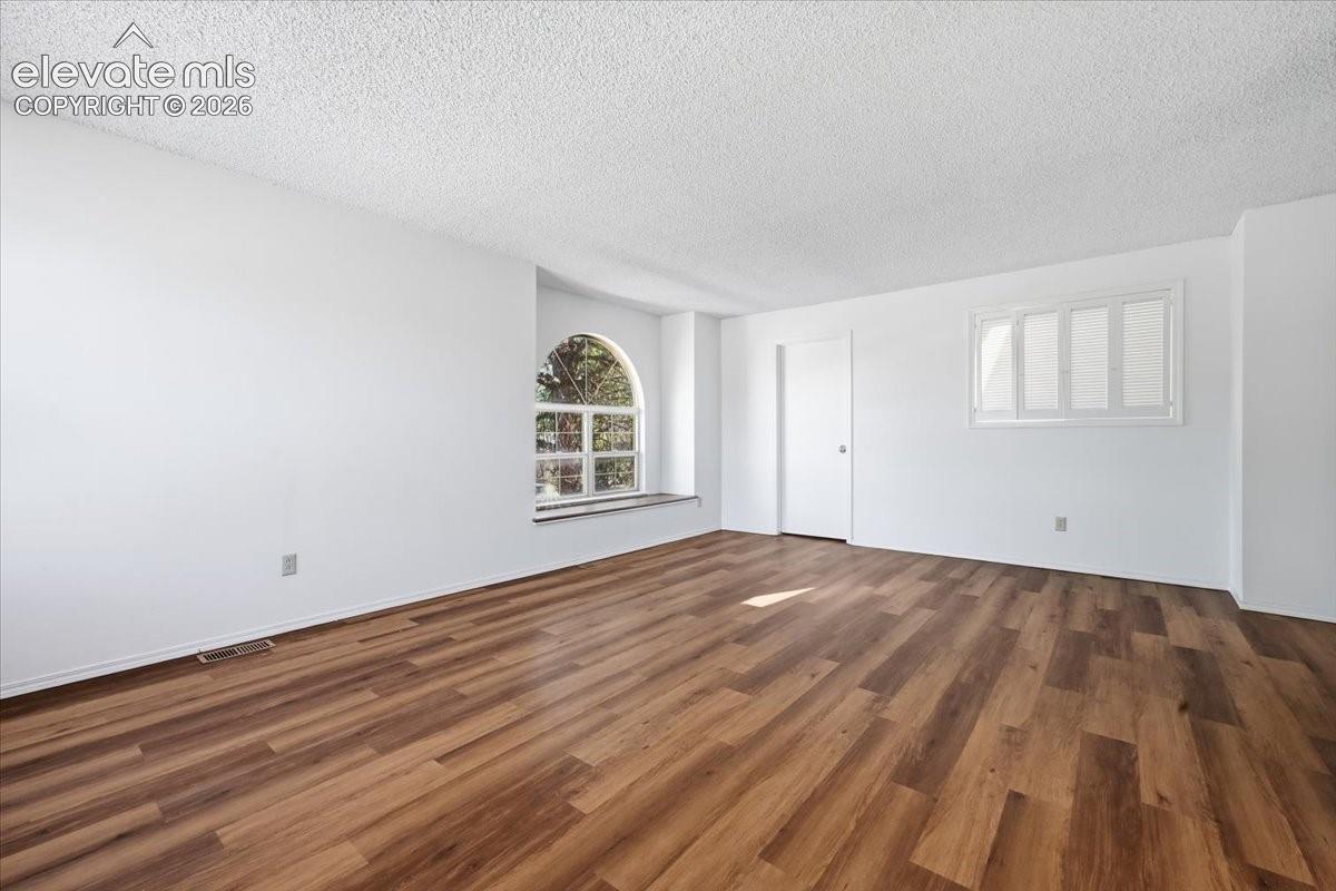 Upper-level bedroom with an arched window and new LVP flooring at , Colorado Springs, CO.