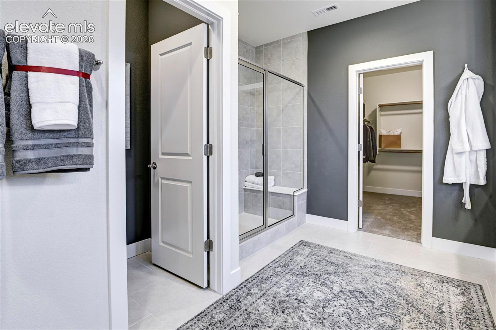 Walk-in shower with clear glass enclosure and integrated bench