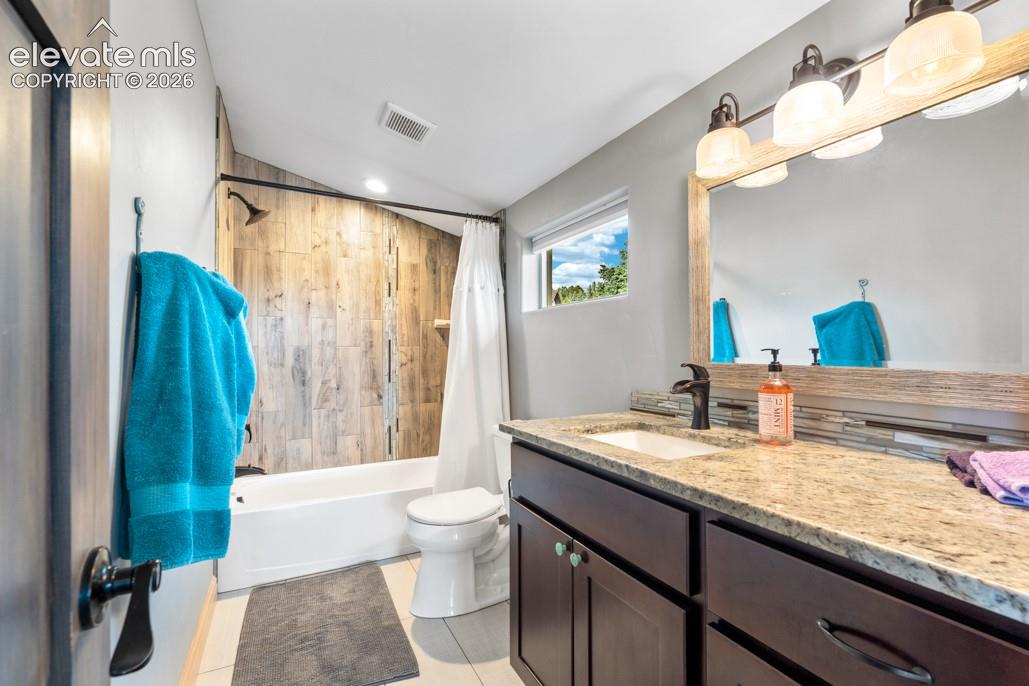 Vanity with a granite-style countertop, undermount sink, and dark wood-finish cabinetry