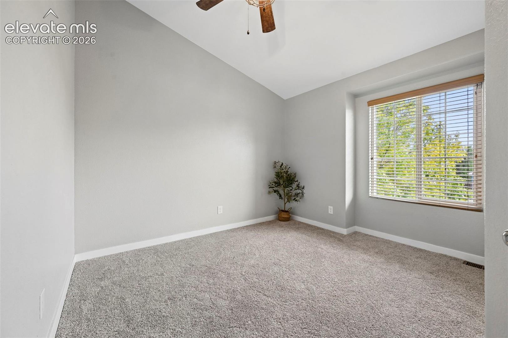 vaulted ceiling, carpeted flooring, closet and ceiling fan