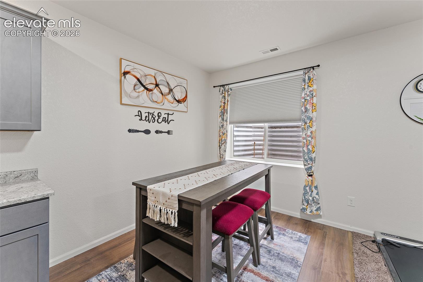 Shaker-style cabinetry with neutral countertops and wood-finish flooring