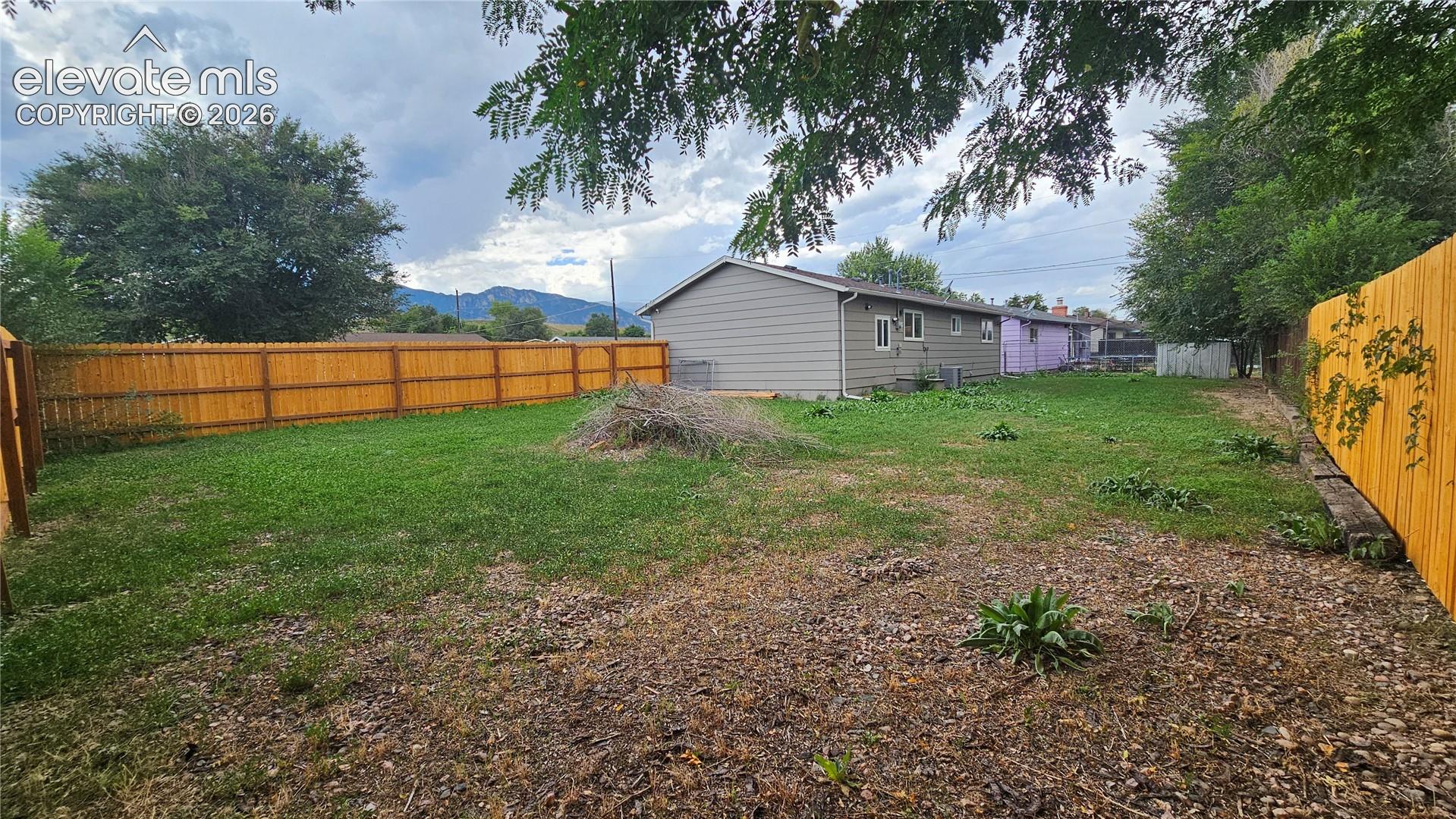 Expansive backyard featuring a wood privacy fence