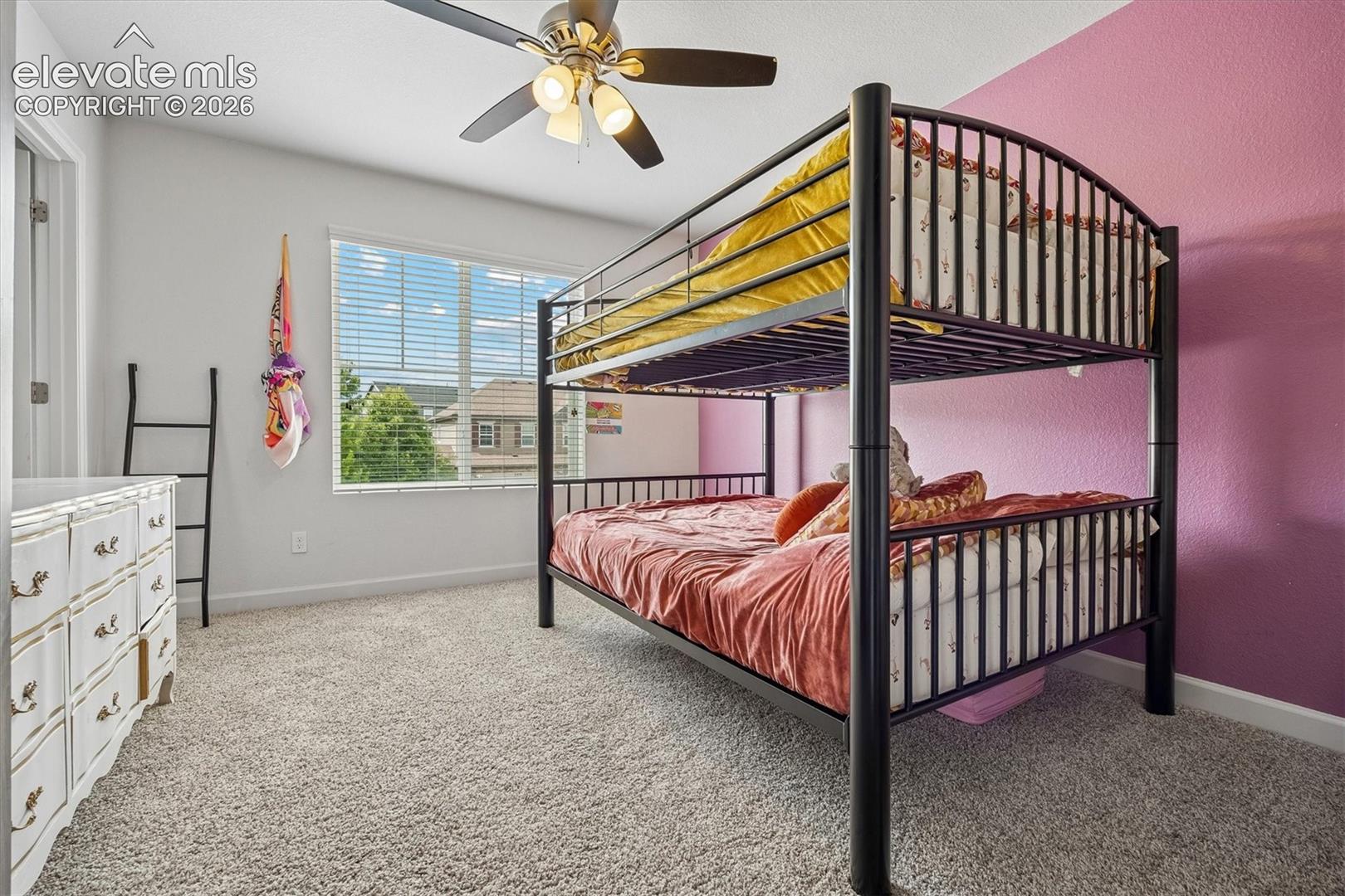 Bedroom featuring light gray wall paint and one accent wall with a textured fuchsia finish