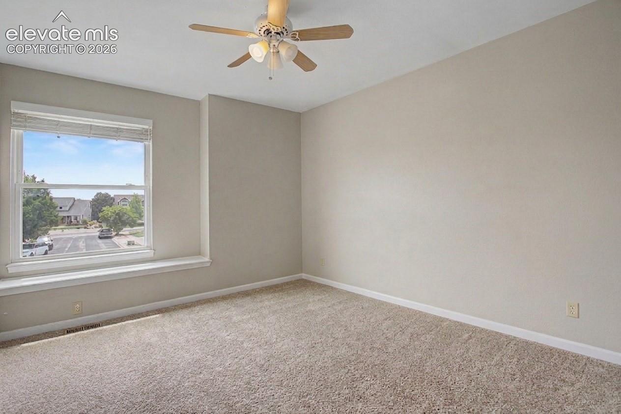 Carpeted room with a ceiling fan, recessed window, and light-toned wall paint