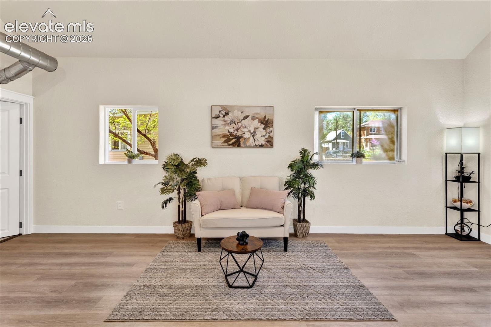 Expansive room with wood-finish flooring and light-toned walls