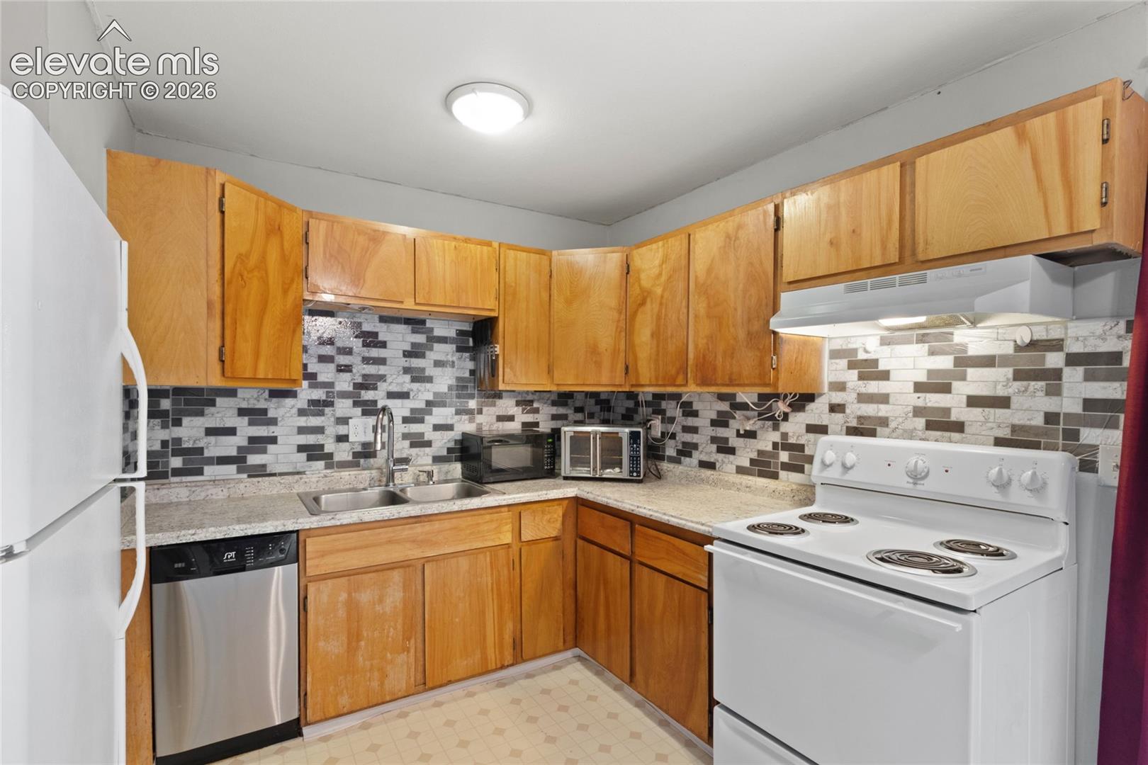 Kitchen with included stove/range, dishwasher, and refrigerator 