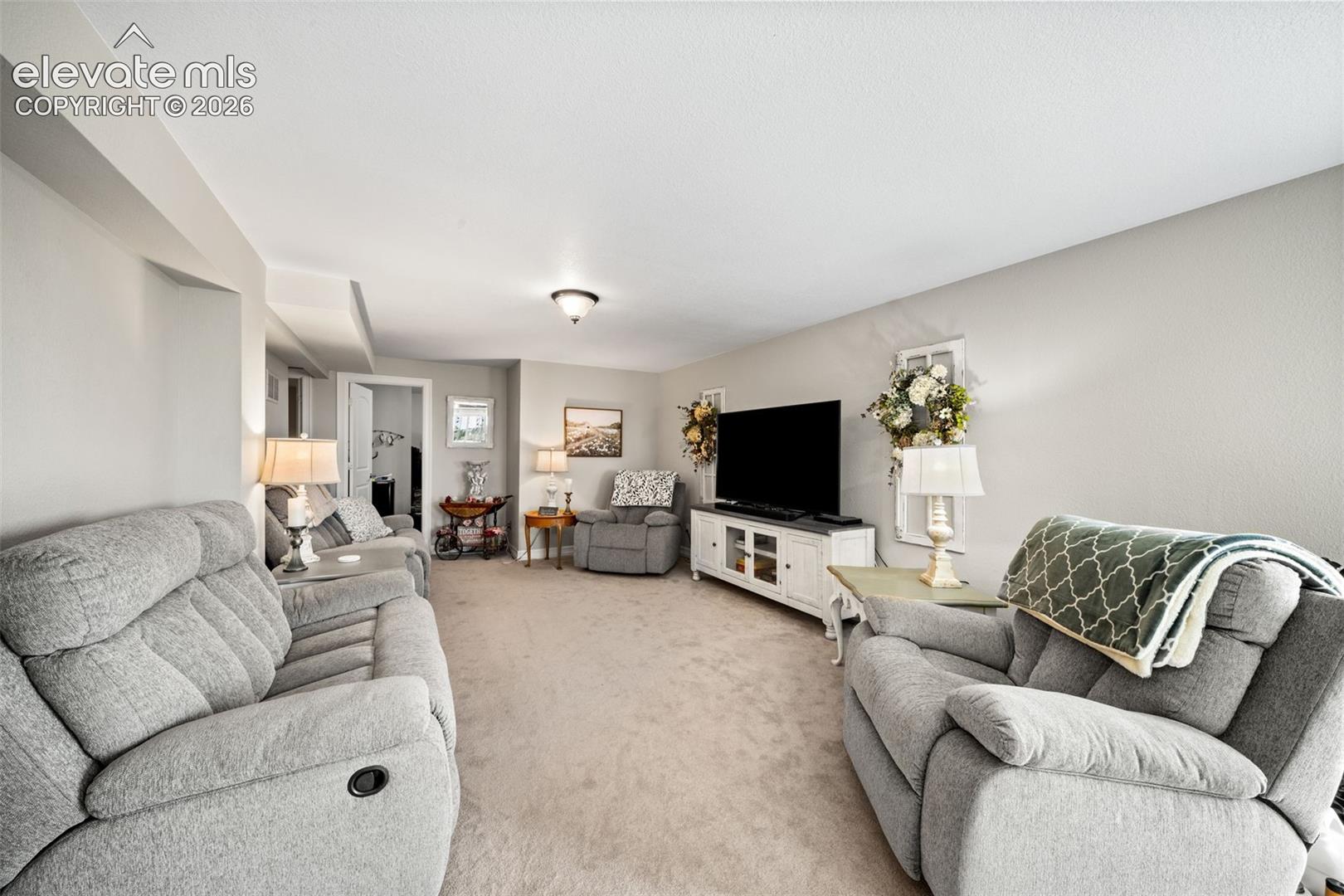 Spacious room featuring neutral carpeting, light gray walls, and recessed lighting