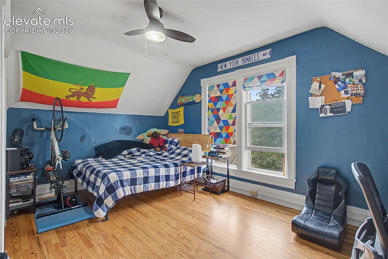 Upper bedroom featuring wood flooring and ceiling fan