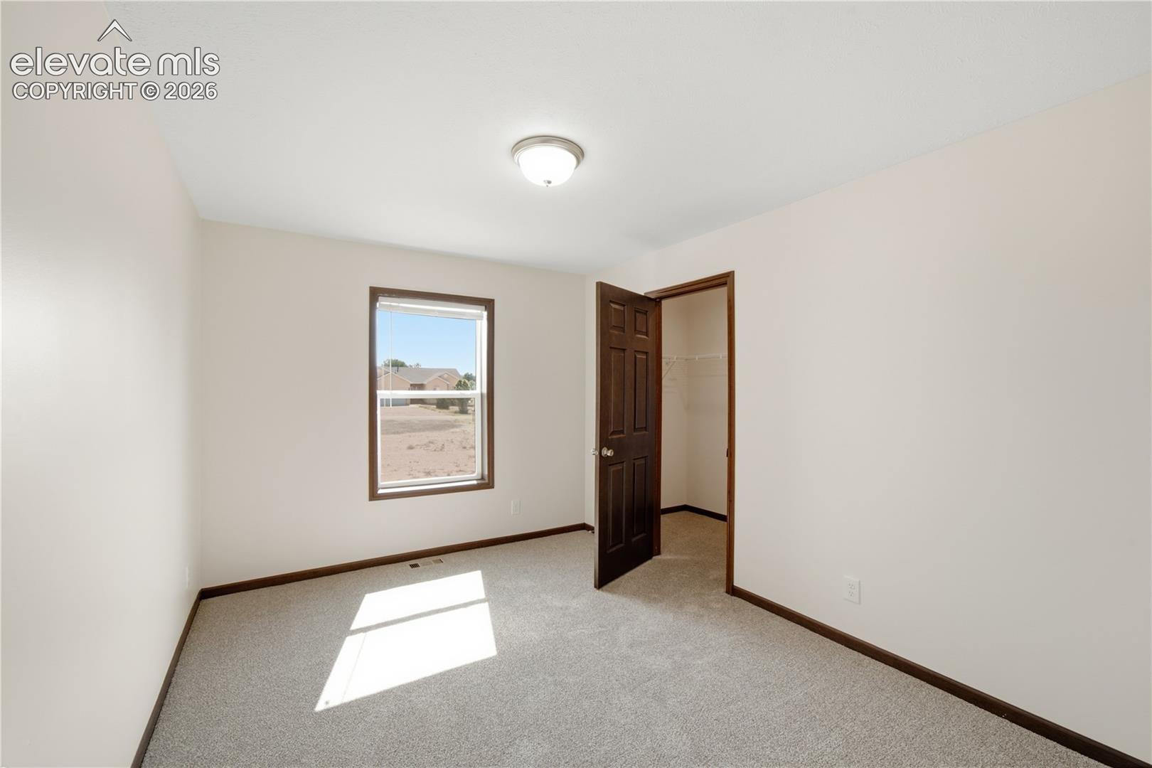 Neutral wall paint with contrasting dark wood-finish trim and doors