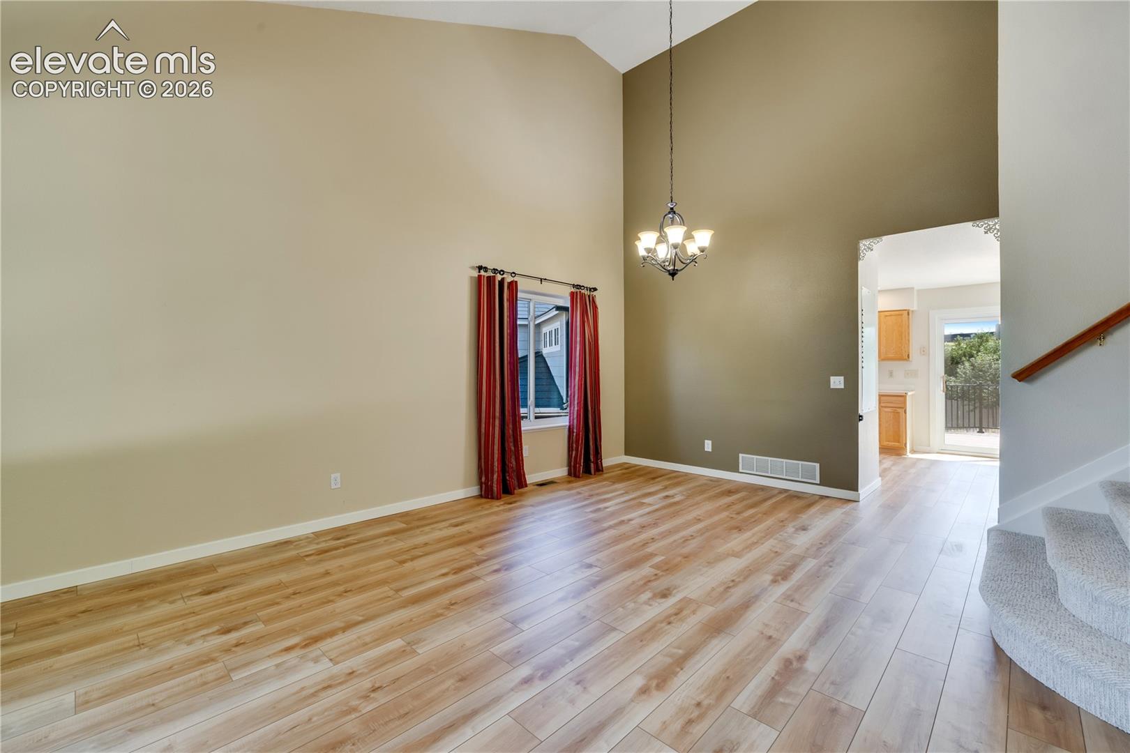 Living room/dining room combo has vaulted ceiling