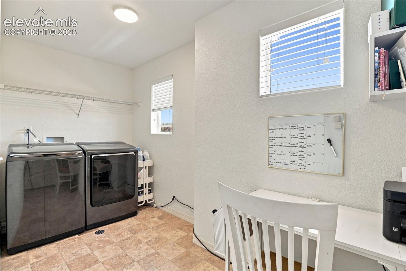 Dedicated utility space with tiled flooring and dual windows