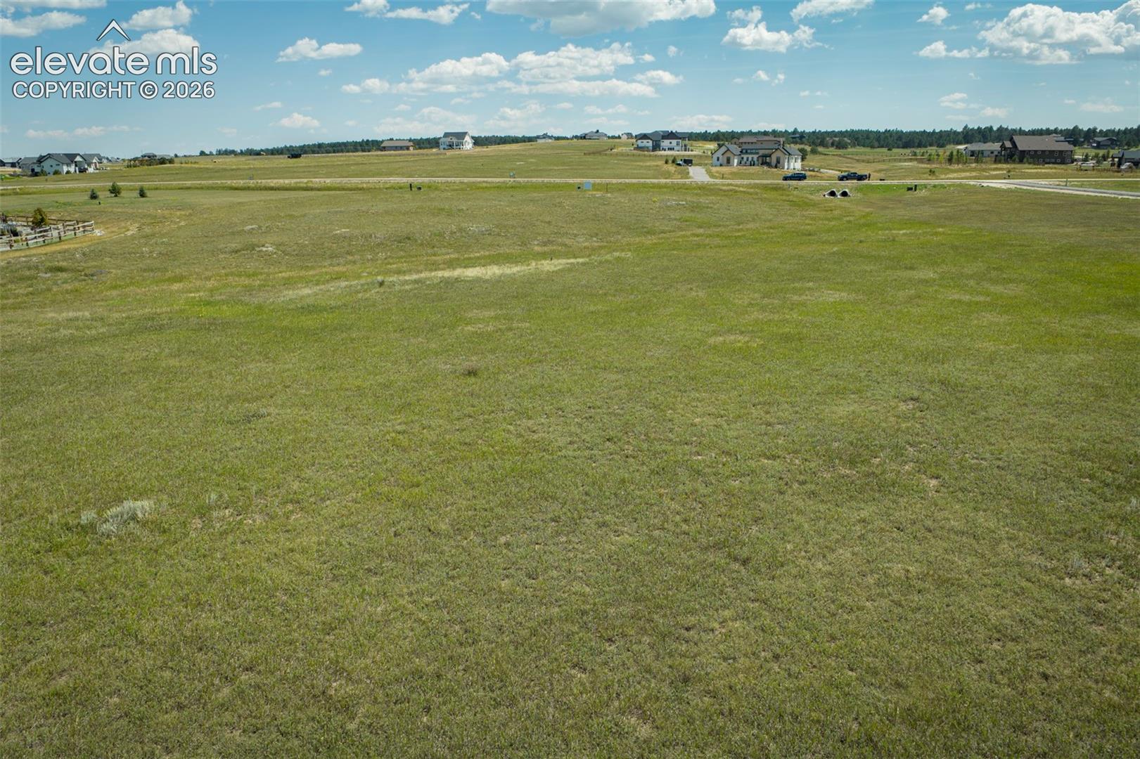 Expansive vacant lot featuring native grasses and rolling topography