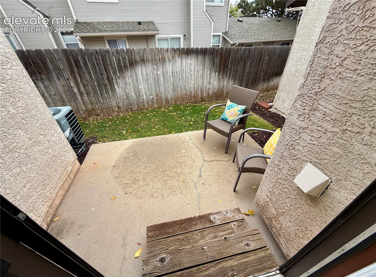 Concrete patio featuring wood-plank steps, and exterior stucco siding