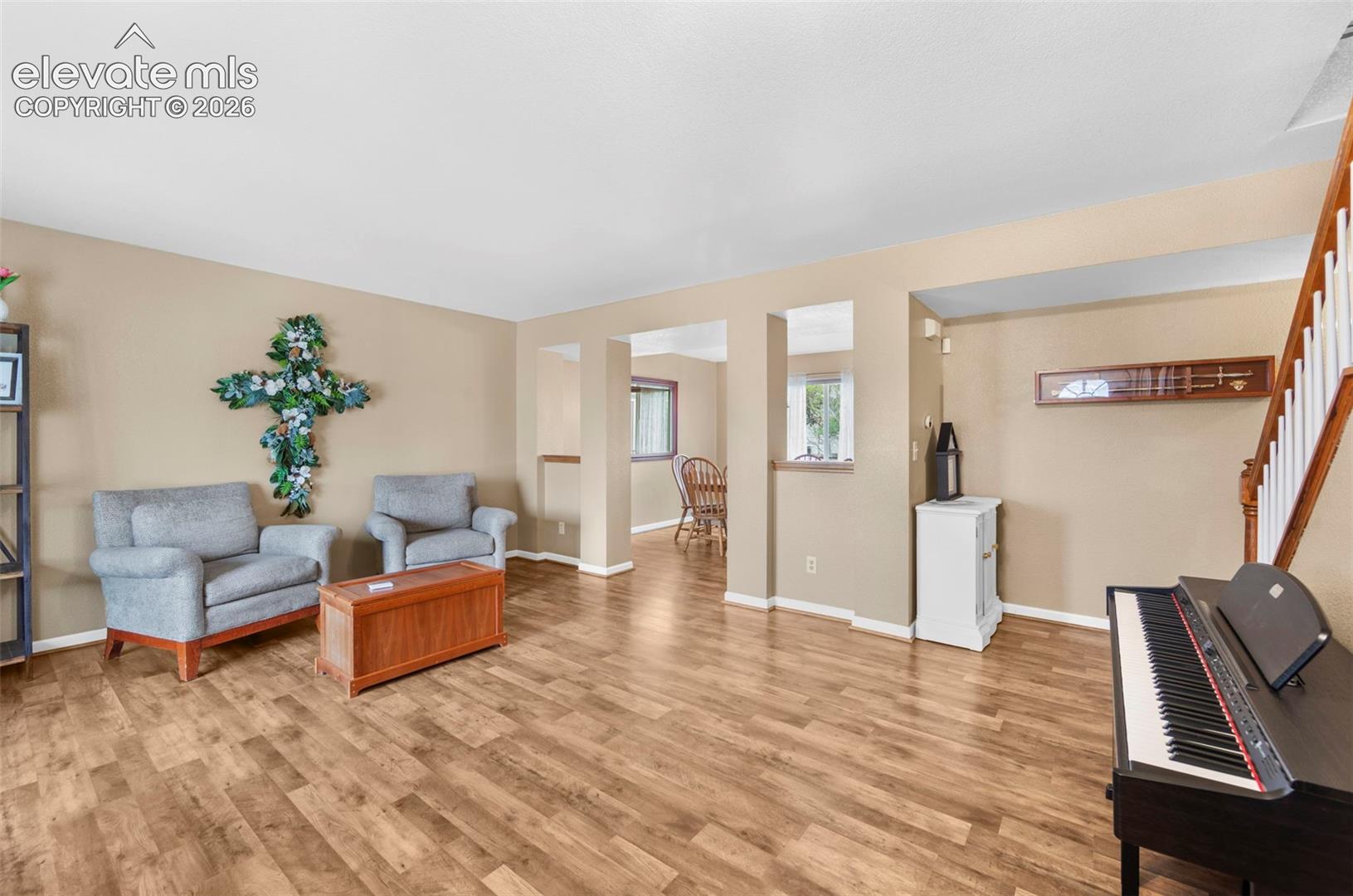 Spacious living area featuring wood-finish flooring, neutral wall tones, and architectural cutouts