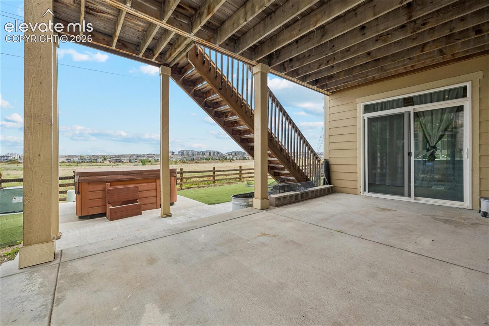 Covered patio space featuring a concrete surface and a hot tub