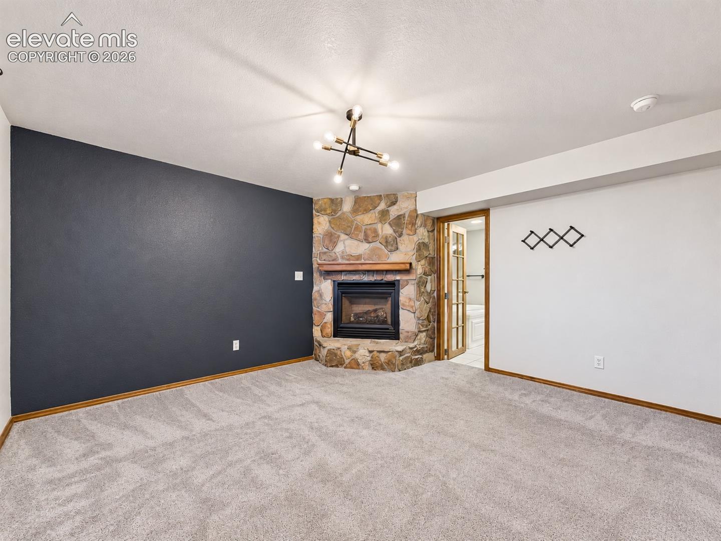 Spacious primary suite highlighted by a beautiful stone fireplace, creating a warm and inviting retreat. Lower Level
