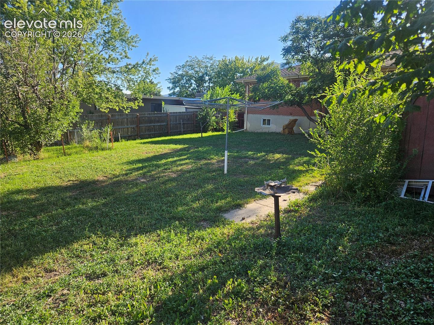 Backyard with privacy fence and some mature trees