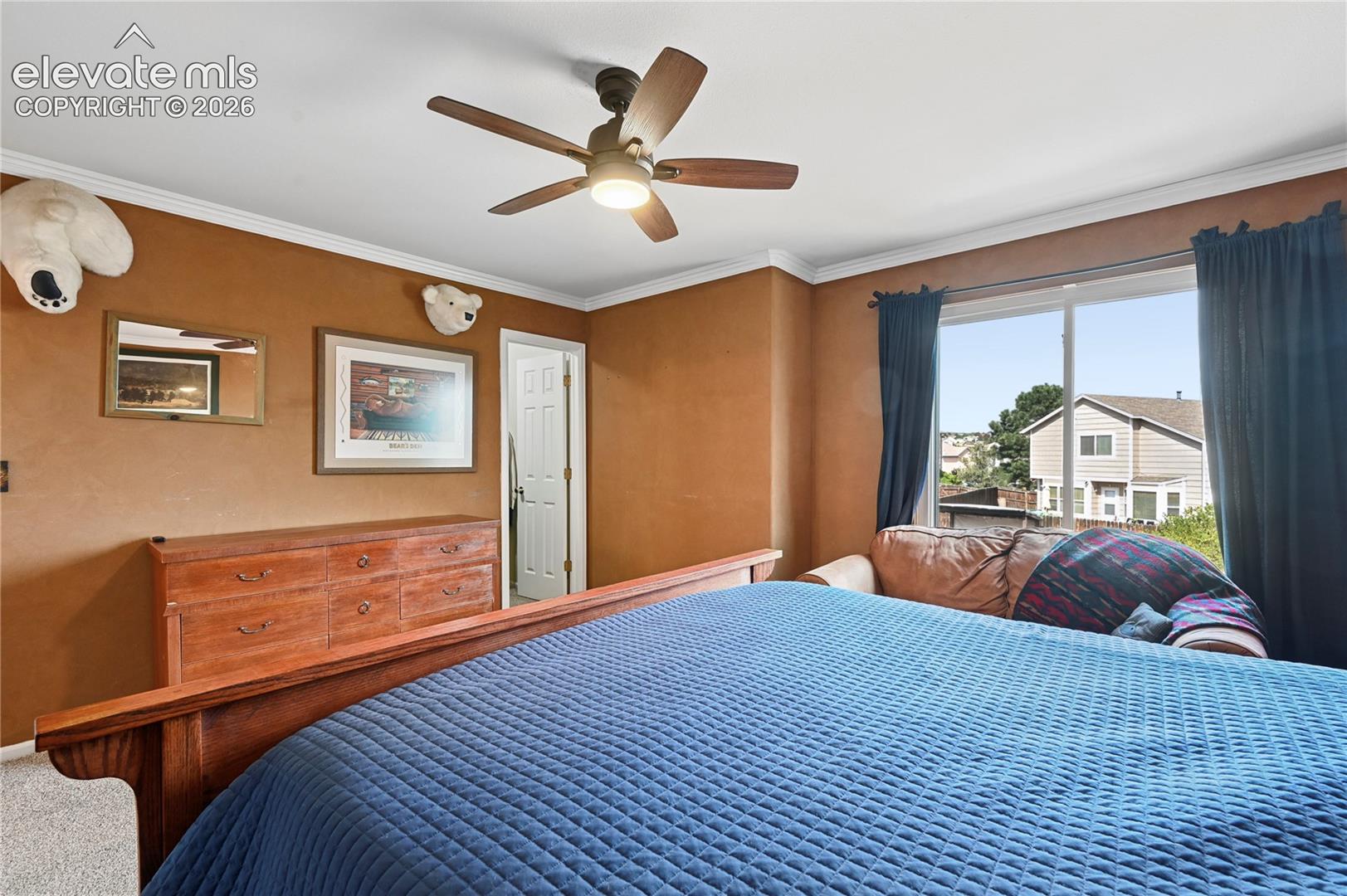 Primary bedroom suite upstairs with backyard views and walk-in closet