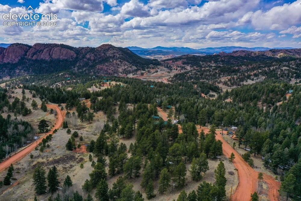 Birds eye view of property with a mountain view and a wooded view