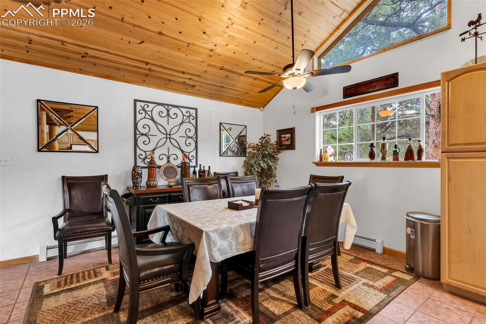 Tile floor, ceiling fan, and plenty of natural light in dining area next to kitchen