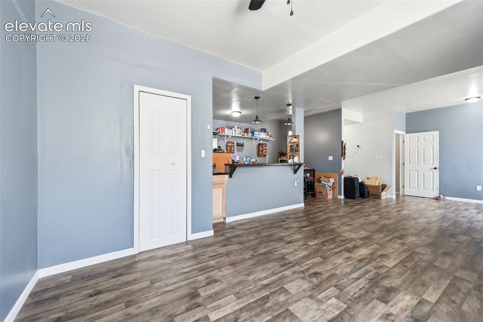Spacious interior featuring wood-finish flooring, light blue wall paint, and white trim