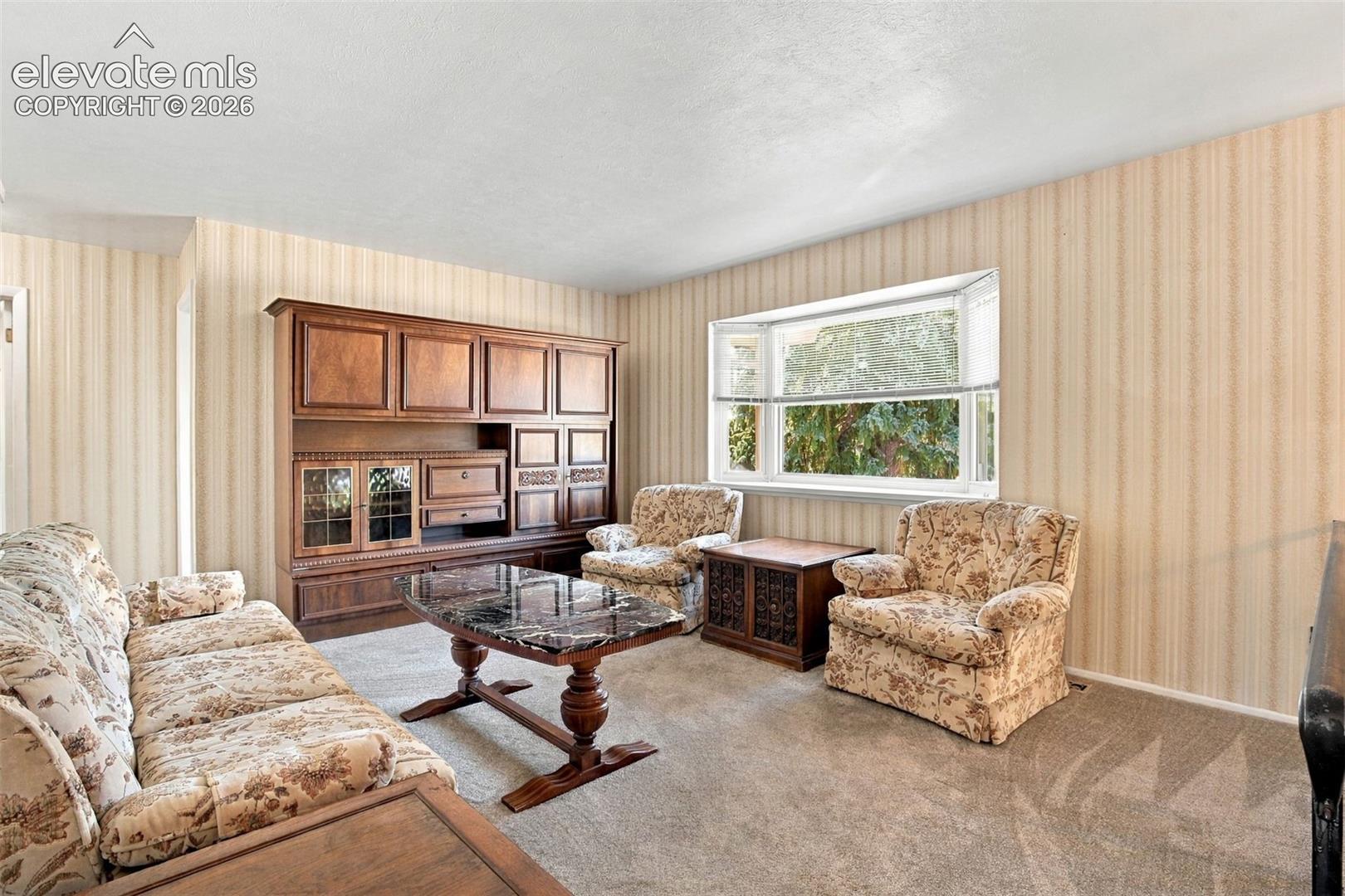 Built-in wall-to-wall cabinetry, bay window, and wallpapered walls