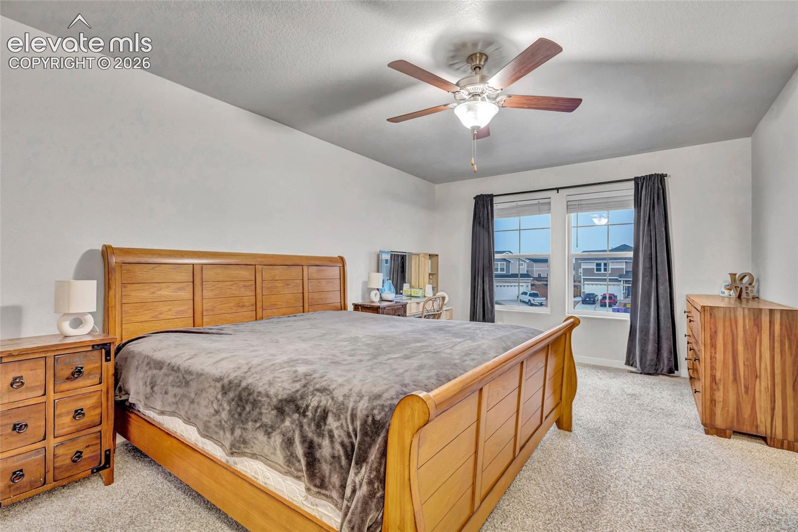 Recessed ceiling with a ceiling fan light fixture, light gray wall paint, and gray carpet flooring