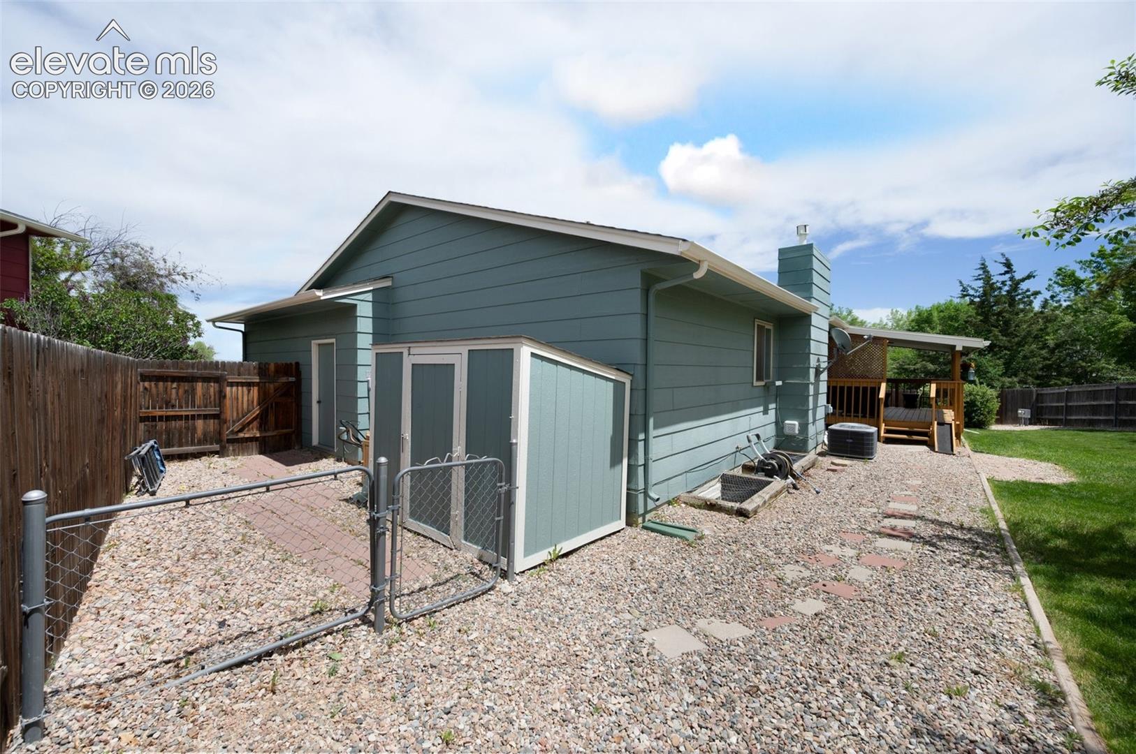 View of outbuilding with a gate, a fenced backyard, and central air condition unit