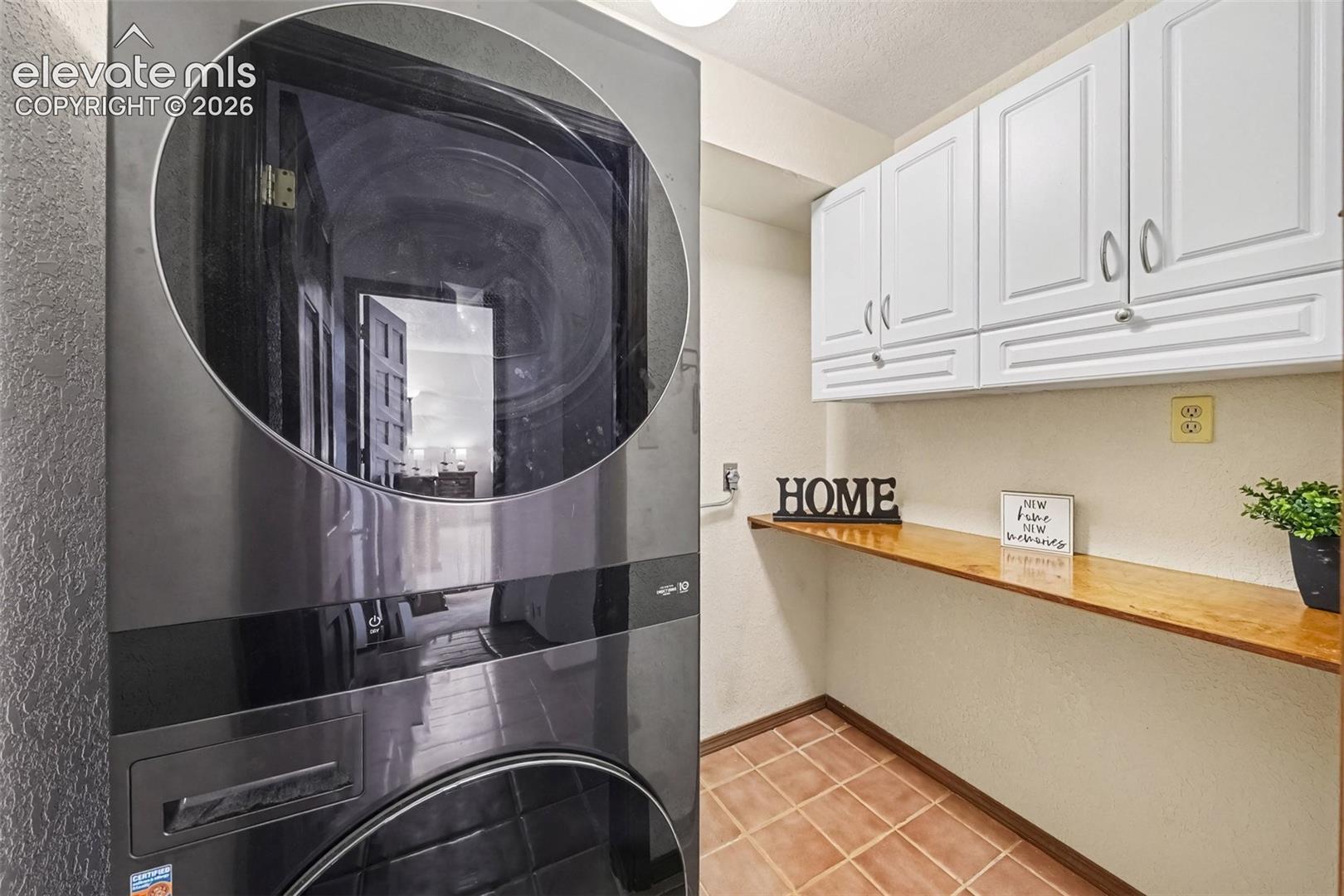Convenient main-level laundry room with ample cabinetry for storage and organization, making laundry day easy and efficient