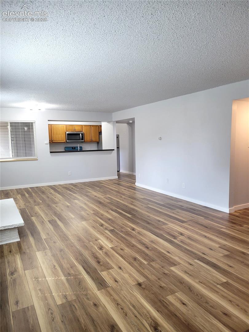 Spacious living area featuring wood-finish flooring throughout