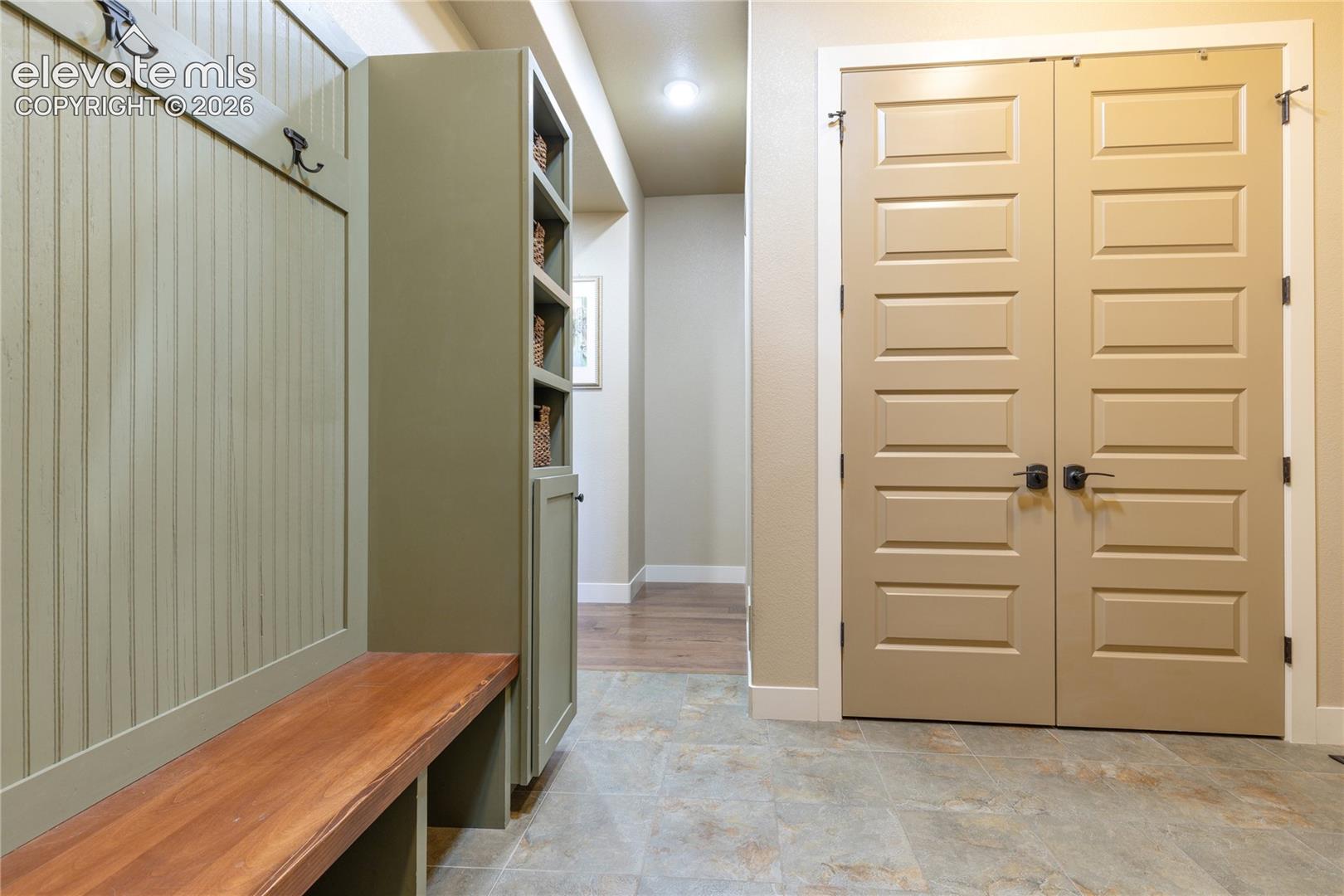 Generous built-in cabinetry + dedicated coat storage enhance the mudroom, while a nearby walk-in pantry keeps household essentials organized + accessible.