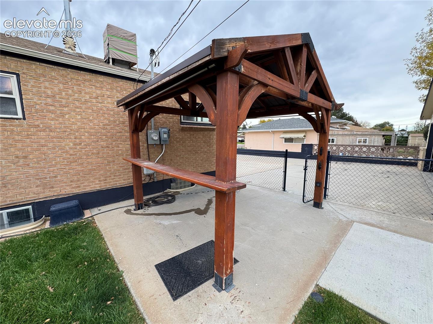 Outdoor timber-framed gazebo with a metal roof and integrated counter