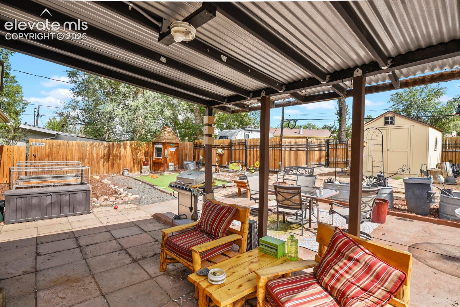 Covered patio with corrugated metal roof and exposed wood beams