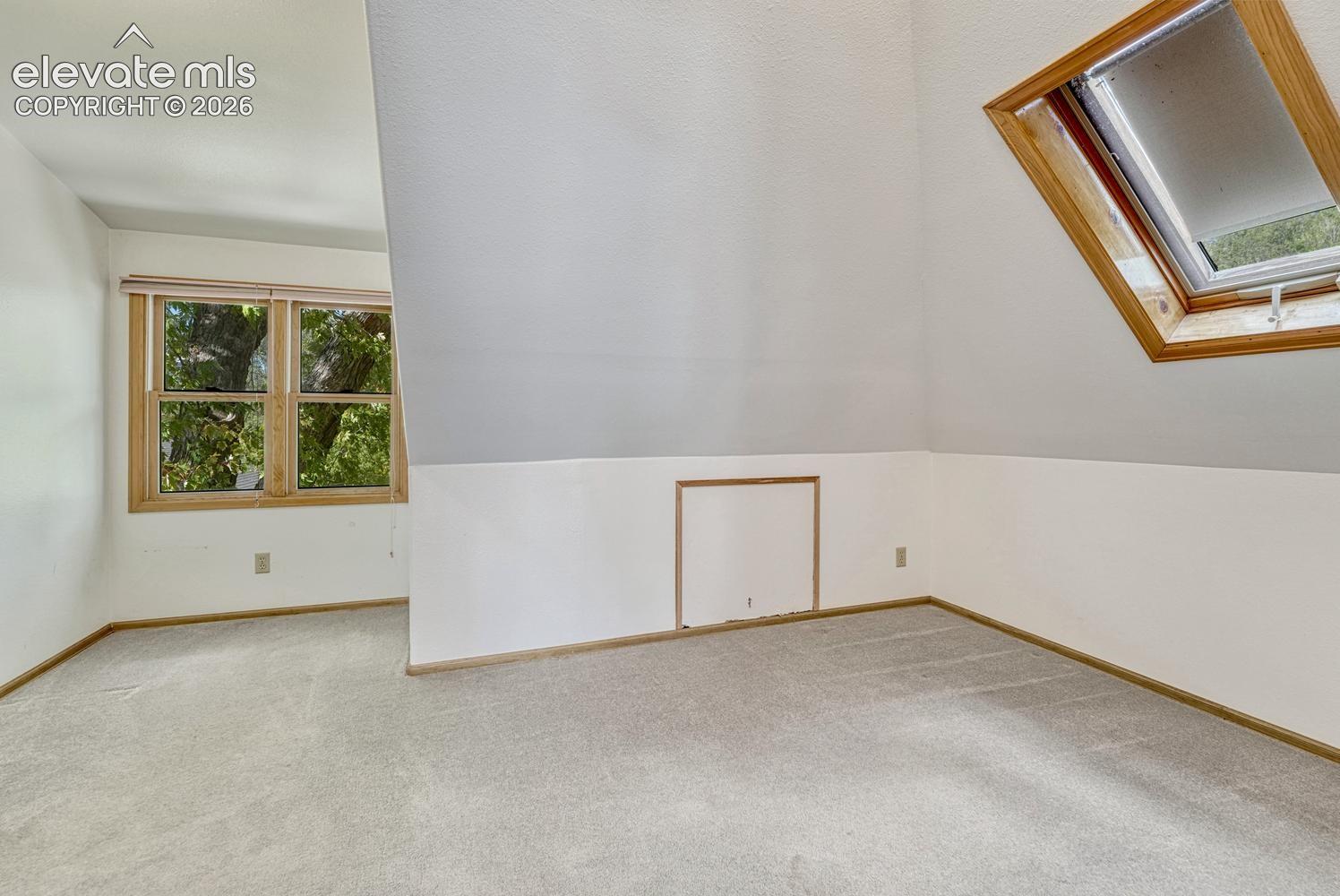 Sloped ceilings, skylight, and carpeted flooring