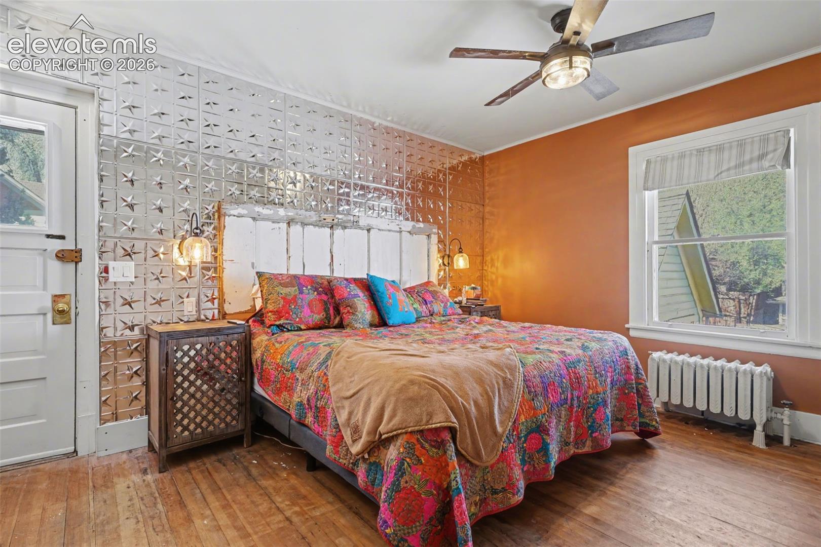Primary bedroom with hardwood flooring