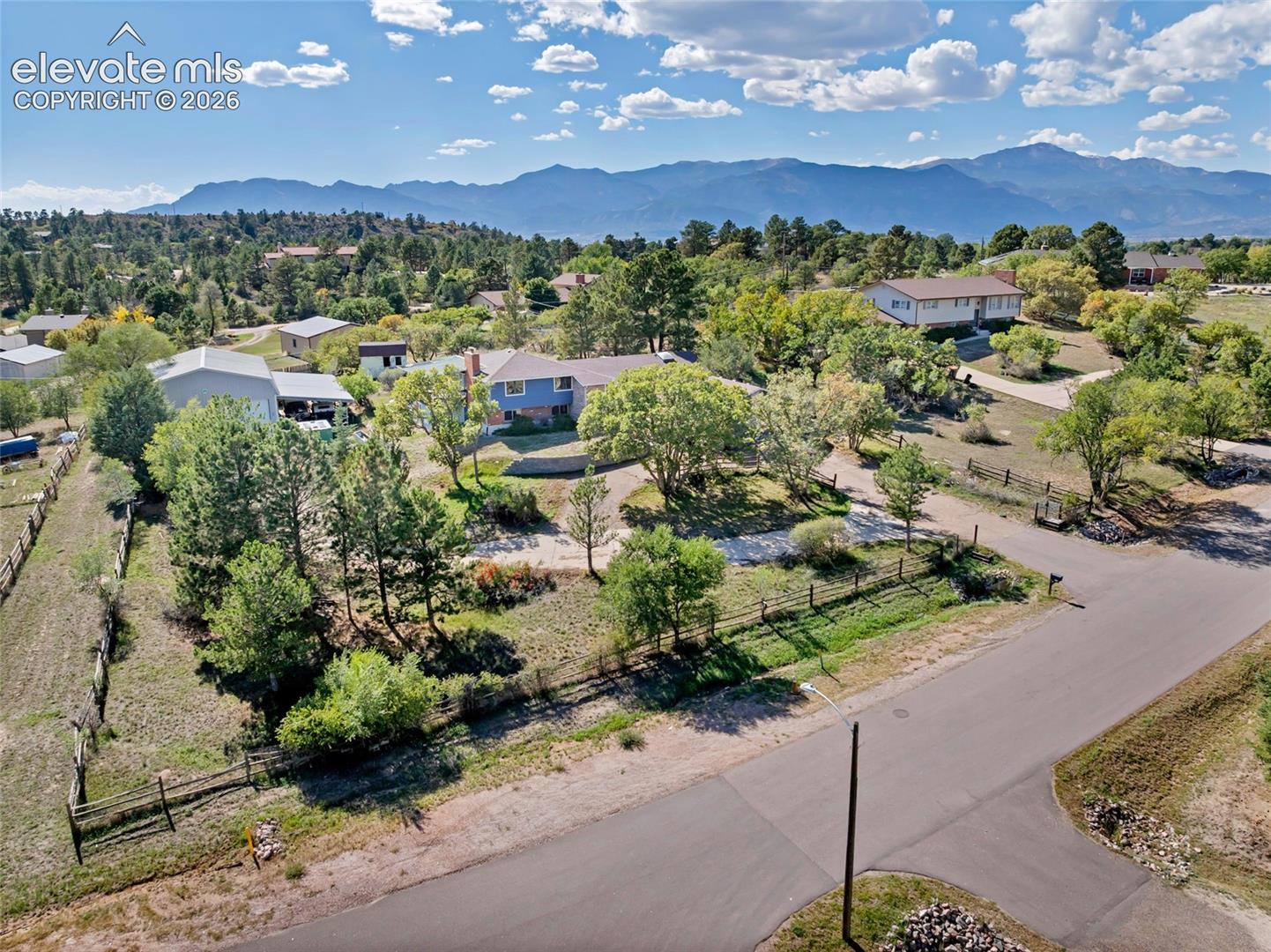 Expansive property with mature trees, a natural landscape, and mountain scenery in the background