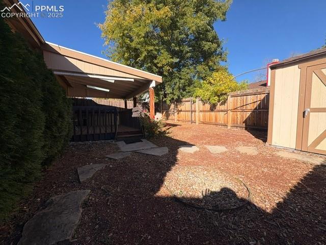 View of yard featuring a deck and a storage shed