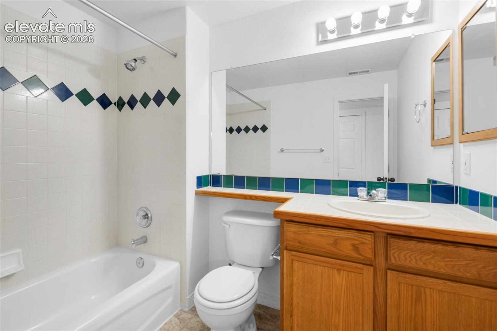 White ceramic tile shower surround with decorative accent tiles