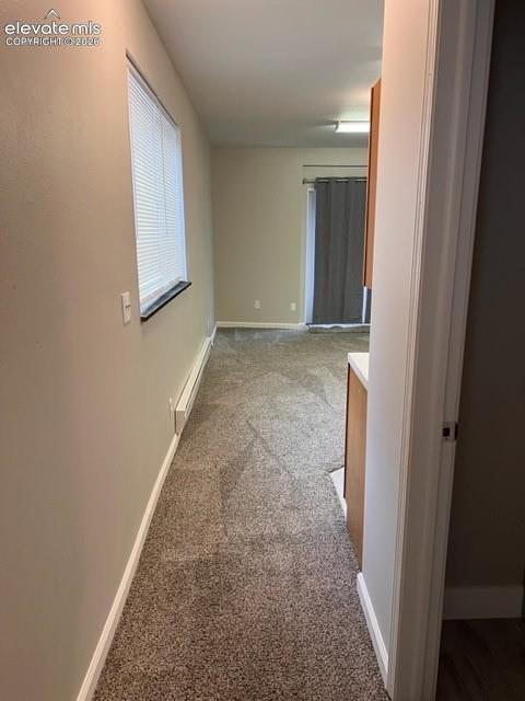 Neutral-toned wall paint, neutral carpeting, horizontal window blinds, and natural light exposure