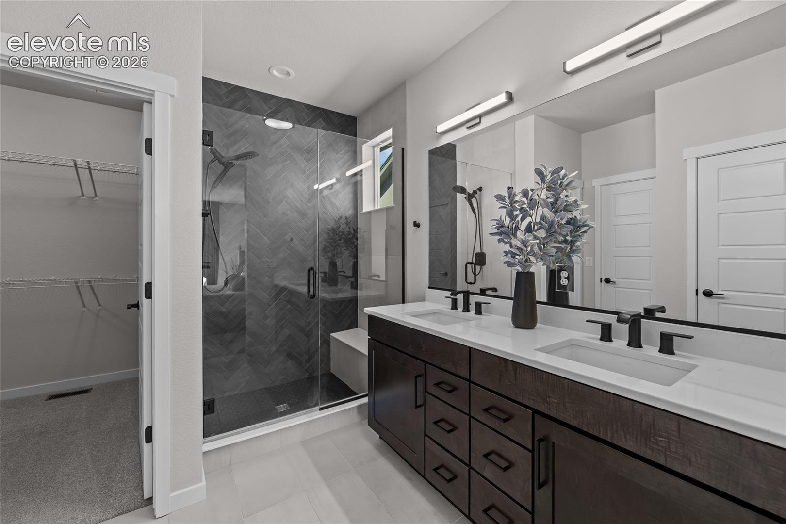 Double vanity with dark wood cabinetry, solid surface countertops, and rectangular undermount sinks