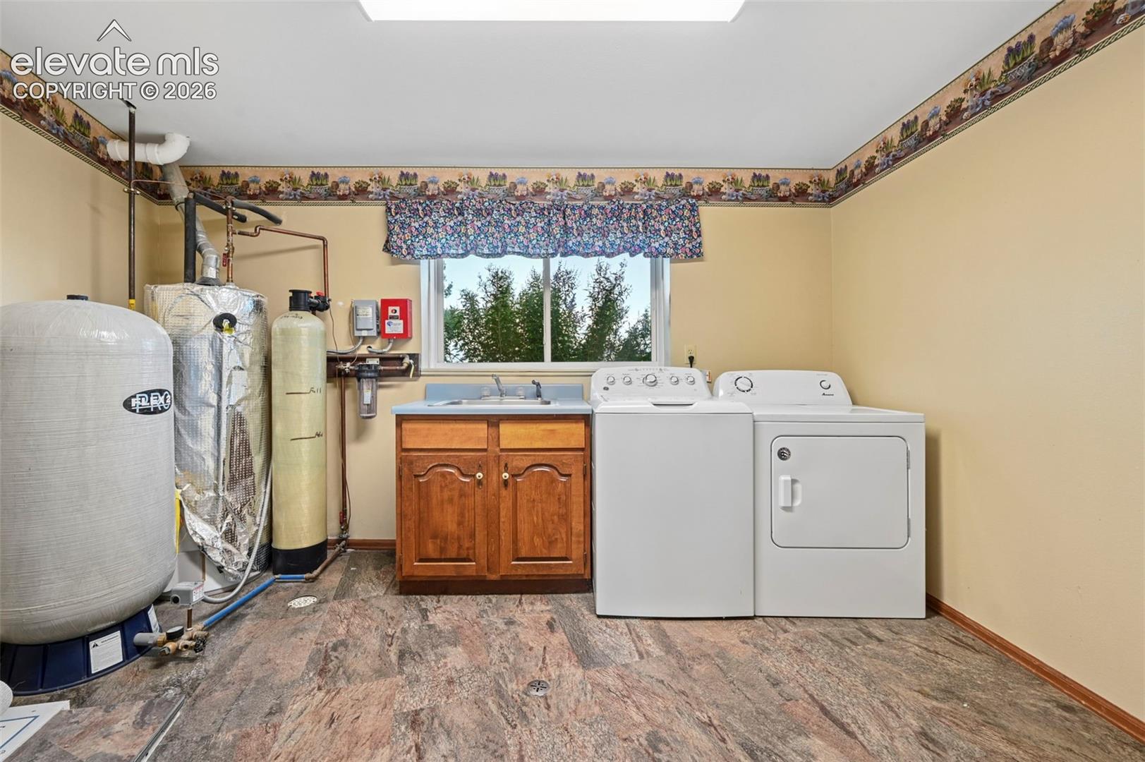 Laundry area with hot water heater, utility sink, and water softener