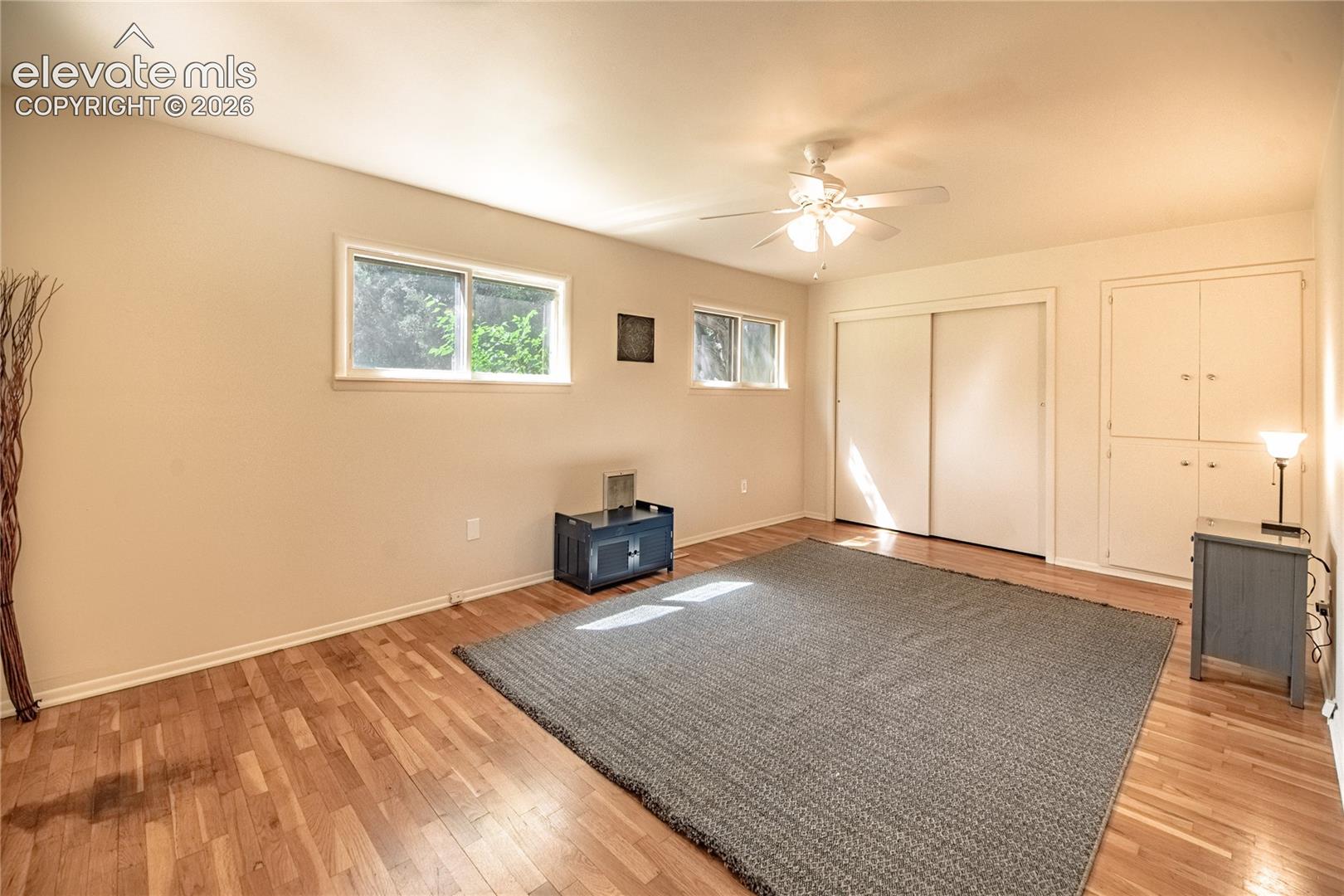 Wood-finish flooring throughout, complemented by a ceiling fan with integrated lighting