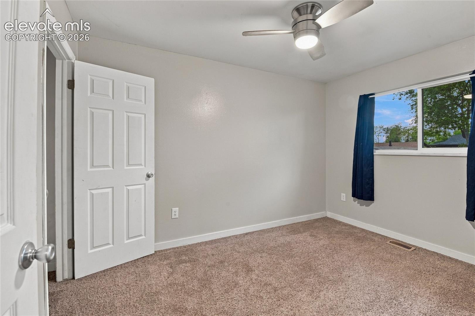 Main level secondary bedroom or home office with a ceiling fan with integrated lighting