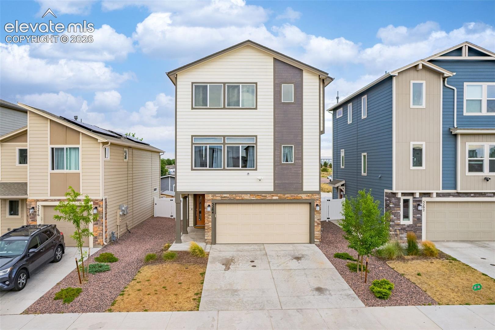Modern facade featuring a mix of horizontal siding, vertical accents, and stone veneer