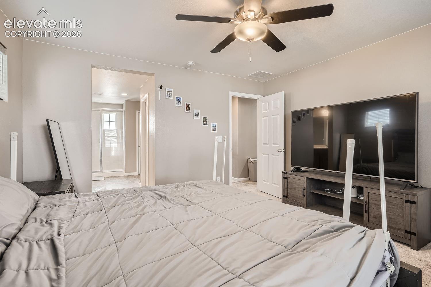 Bedroom featuring neutral wall paint, carpeted flooring, and a ceiling fan with integrated lighting
