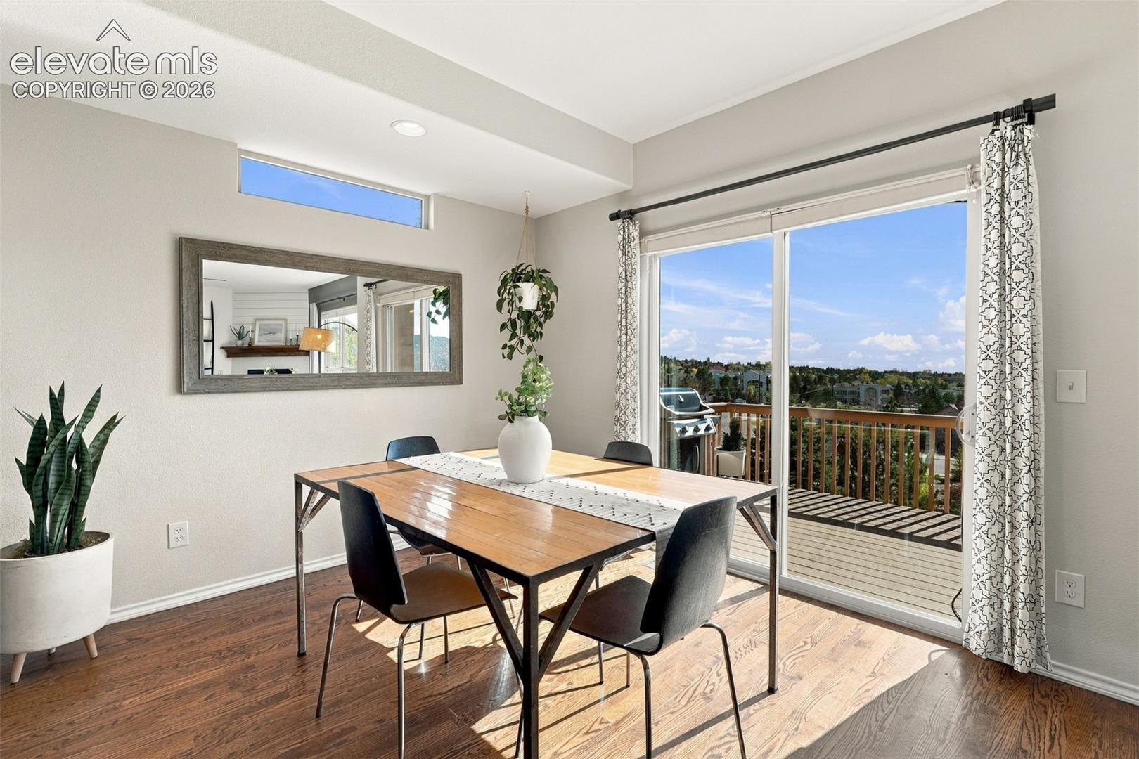 Wood-finish flooring, sliding glass door, elevated outdoor deck, transom window, and recessed lighting