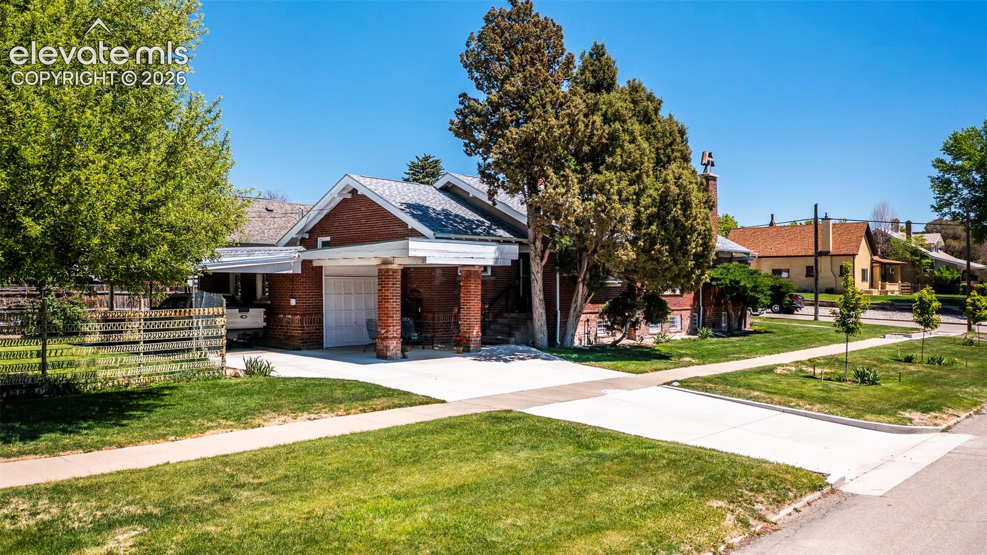 Brick exterior featuring a gabled roof and attached 1 car garage